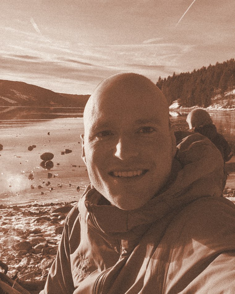 Pascal Timshel by a frozen lake in Norway, smiling, in a warm-toned portrait.