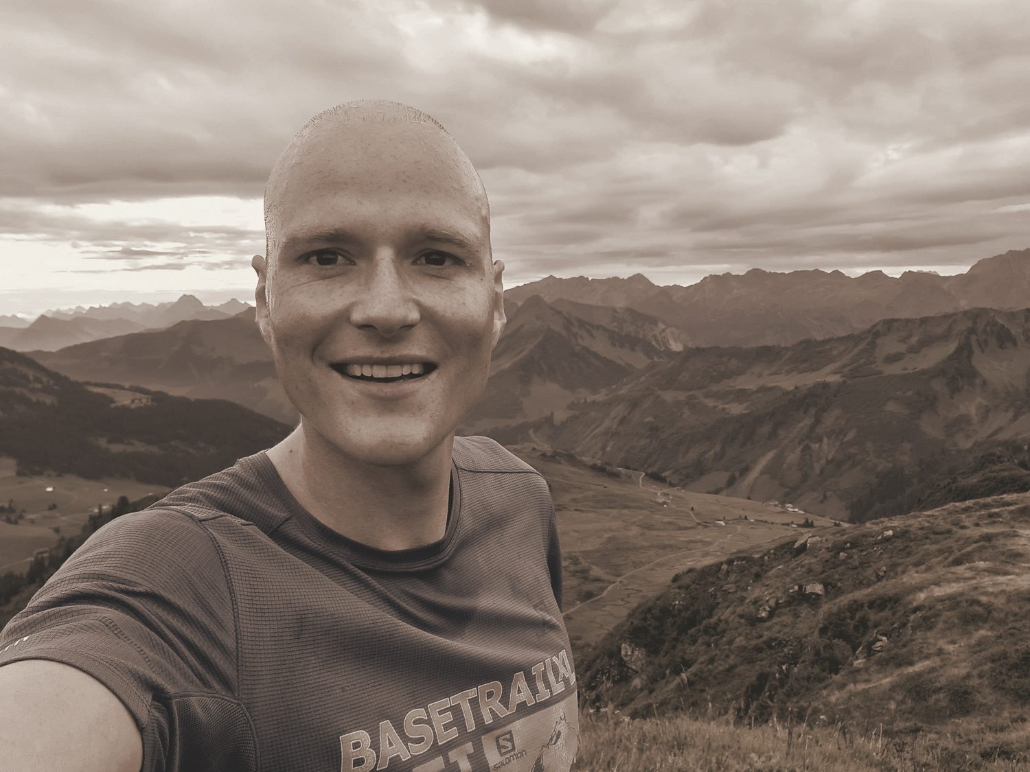 Trail running on a high mountain ridge, mountains behind, in a warm-toned photograph.